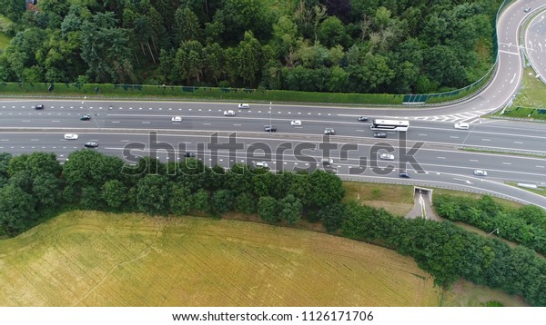 Aerial photo of highway with traffic moving in\
both directions both directions having several lanes showing cars\
commuting and larger\
vehicles