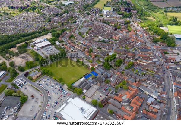 Aerial\
photo of the historical village town centre of Selby in York North\
Yorkshire in the UK showing the British high street in the village\
from above and housing estates in the\
background