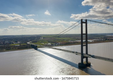 Aerial photo of The Humber Bridge, near Kingston upon Hull, East Riding of Yorkshire, England, single-span road suspension bridge, taken on a sunny day with a few white clouds in the sky.