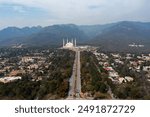 Aerial photo of Islamabad, the capital city of Pakistan showing the landmark Shah Faisal Mosque and the lush green mountains of the city