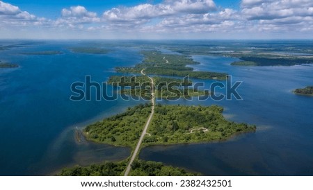Aerial photo of Long Sault Parkway scenic route crossing Thousand Islands archipelago in the Saint Lawrence River near Cornwall, South Stormont, Ontario, Canada. Photo taken by drone in June 2022.
