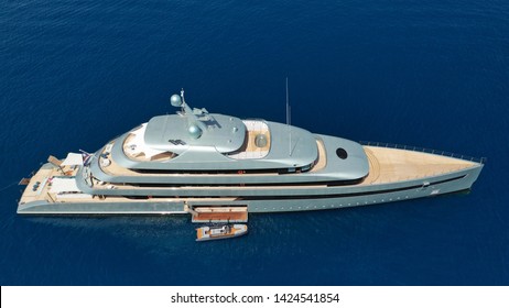 Aerial Photo Of Luxury Yacht With Wooden Deck Docked In Island Of Mykonos Deep Blue Sea Of Super Paradise, Cyclades, Greece