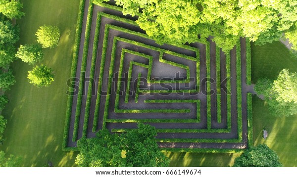 Aerial photo medium altitude above bush maze showing\
different paths just one leading to exit also known as labyrinth is\
path or collection of paths typically from entrance to goal drone\
top-down view