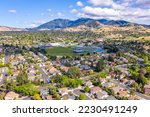 Aerial photo over the city of Concord, California with houses in the foreground and green trees with Mt.Diablo in the background and a blue sky