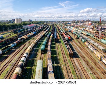 Aerial photo of railway terminal. Freight wagons with goods on railroad station. Cargo transportation. Import and export logistics. Industrial landscape. Top view from drone. Heavy industry.