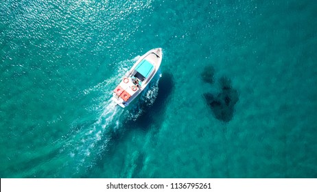 Aerial photo of small vessel cruising in tropical emerald clear sea in Greek Ionian island