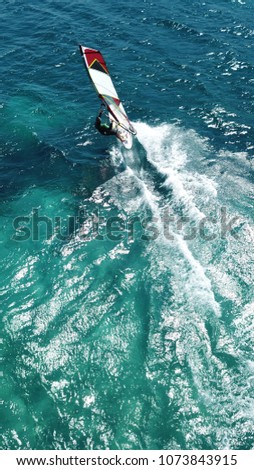 Aerial photo of Surfer in tropical turquoise and sapphire clear waters