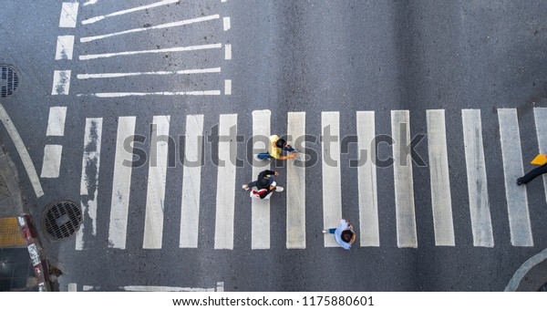 Aerial photo top view of people\
walk on street in the city over pedestrian crossing traffic\
road