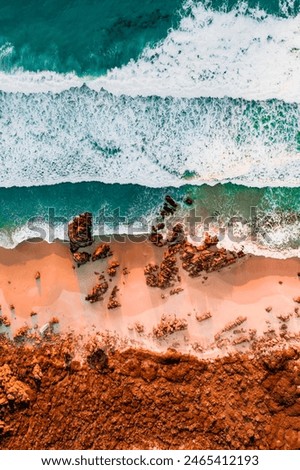 Aerial Photo of turquoise ocean water and red rock cliffs, James Price Point, Kimberley Region, Broome Western Australia