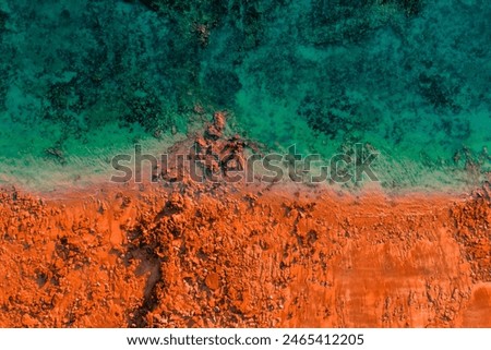 Aerial Photo of turquoise ocean water and red rock cliffs, James Price Point, Kimberley Region, Broome Western Australia