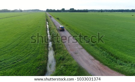 Aerial photo of unpaved road and off road vehicle braking and backing up rural area drone view flight backwards away from the SUV beautiful nature and outdoors area typical offroad SUV scene