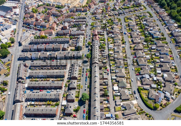 Aerial photo of the village\
of Cleckheaton in Yorkshire in the UK showing a top down view of a\
typical British housing estate and gardens, taken in a sunny\
summers day