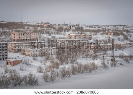 The aerial photo of Vorkuta city, the abandoned Soviet apartment buildings covered in snow during the depressive winter day in the north of Komi Republic, Russia.