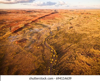 Aerial Photograph Of Australian Outback And Dry Riverbeds Surrounded By Gum Trees And Spinifex.