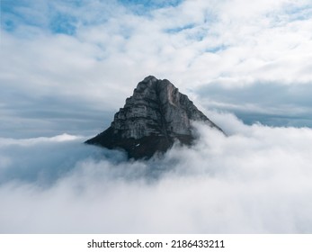 Aerial photograph. Detail of the peak of Beriáin, in the Andía mountain range, rising among the white clouds. In the background a deep blue sky with lots of clouds. - Shutterstock ID 2186433211