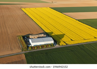Photo aérienne d'une ferme dans un champ de colza à Ablis, à Yvelines, région Île-de-France, France.