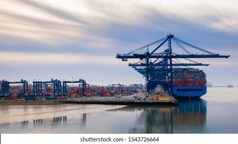Aerial photograph looking through the line of loading gantrys in the early morning mist at Felixstowe container port. rows of stacked containers disappear into the distance early morning clouds streak - Shutterstock ID 1543726664