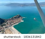Aerial photograph of Nafplion Greece. Old city centre with castle in the harbour entrance. Gulf of Argolis and mountains under a clear sky