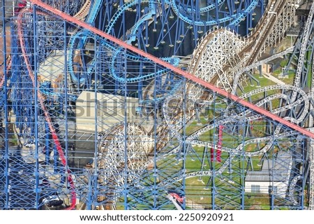 An aerial photograph taken from a helicopter of the rollercoasters at Blackpool Pleasure Beach, Northern England, United Kingdom. Colourful looping amusement rides at a seaside theme park.