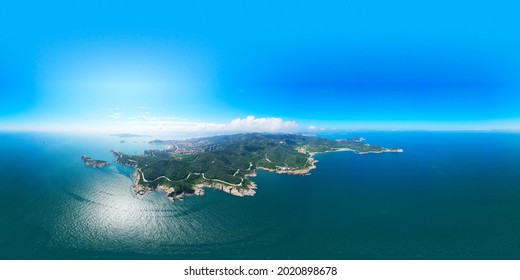 Aerial photography of blue sky and sea; a small green island in the sea