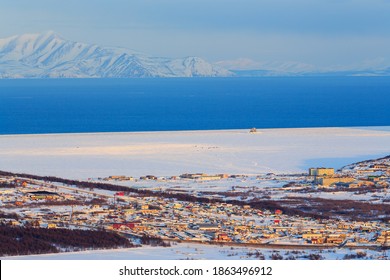 Aerial photography of the coast of the sea bay. Town by the sea. The sea is partially covered with ice. Mountains in the distance. Suburb of Magadan, Magadan Region, Far East Russia. Sea of ​​Okhotsk. - Powered by Shutterstock