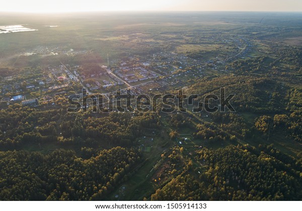 Aerial photography with a drone. Village with green\
forest, road and lake.