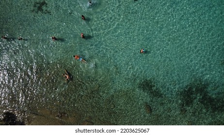 Aerial Photography Of The Earth From A Height. Landscape With Blue Water And Aerial View From   Flying Dron. Swimming Tourists