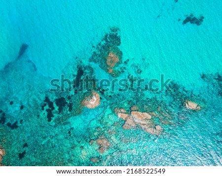 Aerial photography of the incredible landscape of turquoise waters and cliffs of Cala del Pilar, in the northern part of Menorca, Balearic Islands. A paradise of turquoise blue waters, red sand.
