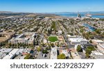 An aerial photography over the city of Pittsburg, California downtown with a refinery in the background and a blue sky with room for text