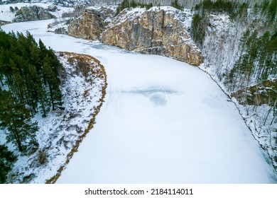 Aerial Photography Of The River In Winter, The Turn Of The River In Winter, The River Is Covered With Ice And Snow. Forest Grows On The Banks