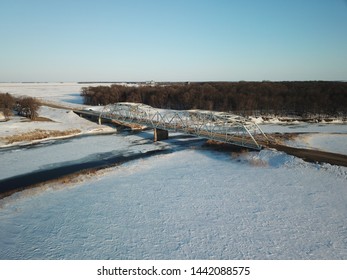 Aerial Photography Of A Rural Bridge Spanning The Frozen Red River Between Minnesota And North Dakota.