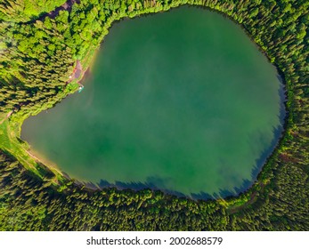 Aerial photography of Saint Ann volcanic lake located In Romania, Harghita county. Photography was taken from a drone with camera pointing straight down. Photography of a blue coloured lake from above