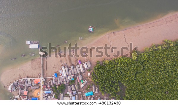 aerial photography a small\
fishing village name BanSamchong  in Phang Nga province cover by\
pine forest in front of village have pier for transport to Andaman\
sea. 