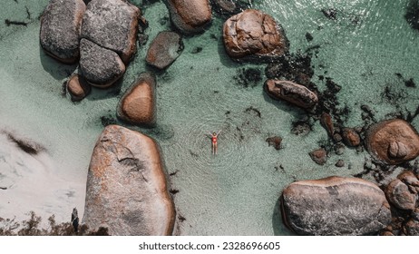Aerial picture of a girl swimming in a fairy pool in Albany, Australia. Shallow and transparent water. Drone picture. Swimming in paradise in blue water between rocks. - Shutterstock ID 2328696605