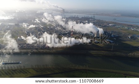 Aerial picture of nuclear power plant and cargo vessel barge moving over canal a thermal power station in which the heat source is a nuclear reactor this plant is located in a heavy industrial zone