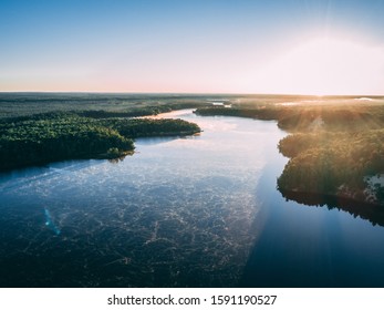 An aerial picture of a river surrounded by islands covered in greenery under sunlight - Shutterstock ID 1591190527