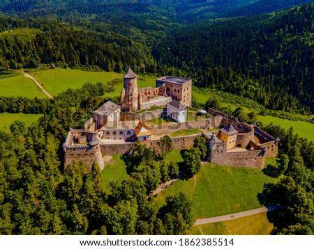 Aerial picture of Stara Lubovna Castle, Slovakia, famous medieval castle on a small hill surrounded by a green forest and fields on summer sunny day