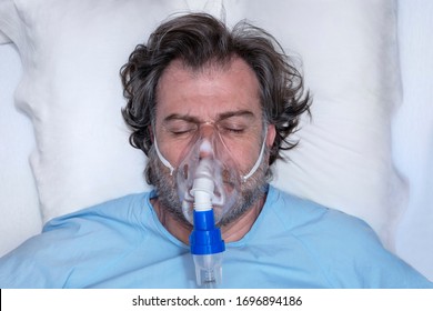 Aerial Portrait Of An Elderly Person, With Oxygen Mask, In A Hospital Bed