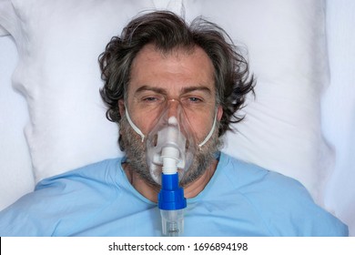 Aerial Portrait Of An Elderly Person, With Oxygen Mask, In A Hospital Bed