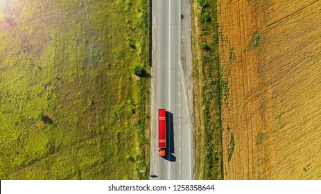 Aerial. Red truck on a road between fields.