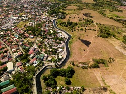 Aerial Of A Residential Suburb And Undeveloped Lands Divided By A Narrow River