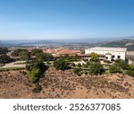 Aerial Ronald Reagan President Library and museum on top of a hill with multiple structures and green vegetation. 