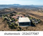 Aerial Ronald Reagan President Library and museum on top of a hill with multiple structures and green vegetation. 