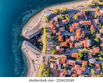 Aerial rooftop cityscape view of a resort old town and blue sea or lake in the background - Shutterstock ID 2254219269