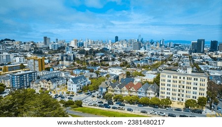 Aerial San Francisco The Painted Ladies with wide view of city and skyscrapers under pretty sky