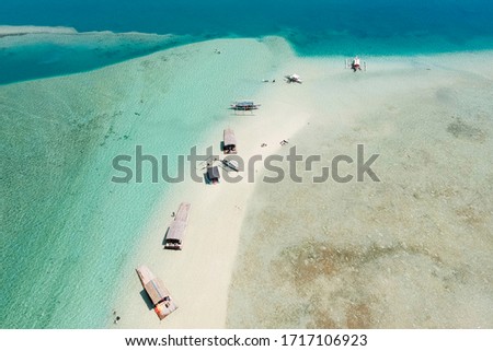 Aerial of a sandbar in Catalagan, Batangas in Luzon Philippines, with boats and rafts moored in the sand.