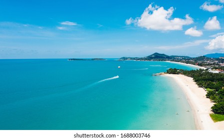 Aerial Scenery View Of White Sand Shore With Turquoise Clear Sea Water. Bird's Eye Panoramic View Of Picturesque Lagoon With Hotels On Beach. Populated Island In Thailand. Water Sport Activity