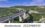 AERIAL: Scenic flying vista of the busy Crni Kal viaduct on a sunny summer day in rural part of Slovenia. Flying above the modern highway bridge crossing the mountainous karst landscape of Slovenia.