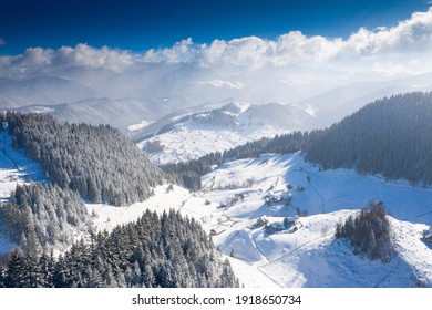 Aerial scenic rural view of the winter landscape from Fundata village in Romania at the bottom of Bucegi Mountains 