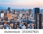 Aerial scenic view of Osaka skyline at sunset. Modern glass skyscrapers seen from Umeda Sky Building.